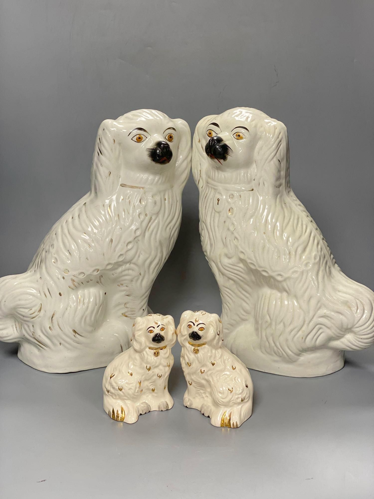 A large pair of Victorian Staffordshire pottery comforter spaniels, 39cm and a pair of Royal Doulton comforter spaniels, 14cm